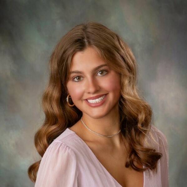 Headshot of Lee Erdman. She has brown hair and is wearing a pink shirt.